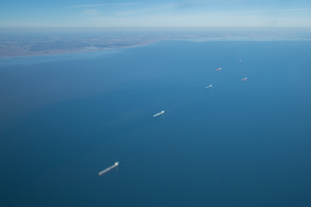 A line of colorful barges cruising out a blue Delaware Bay