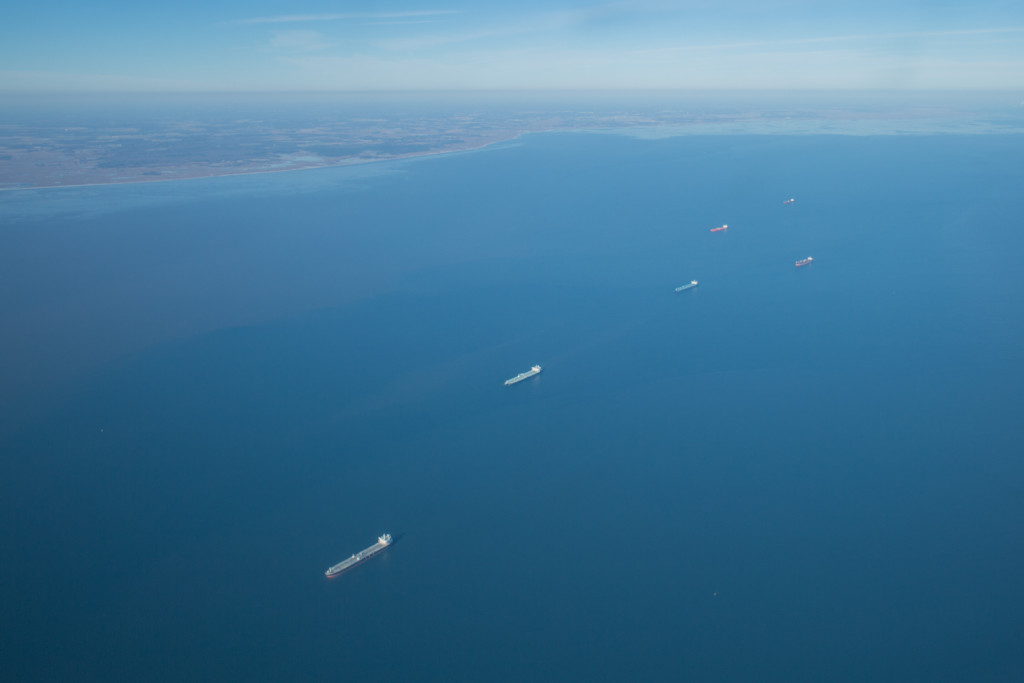 A line of colorful barges cruising out a blue Delaware Bay