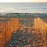 Crossing a dune to a jersey shore beach at sunset