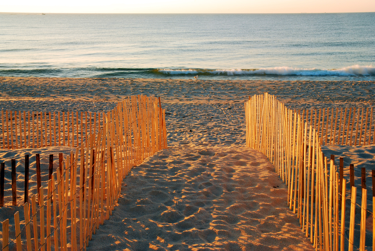 Crossing a dune to a jersey shore beach at sunset