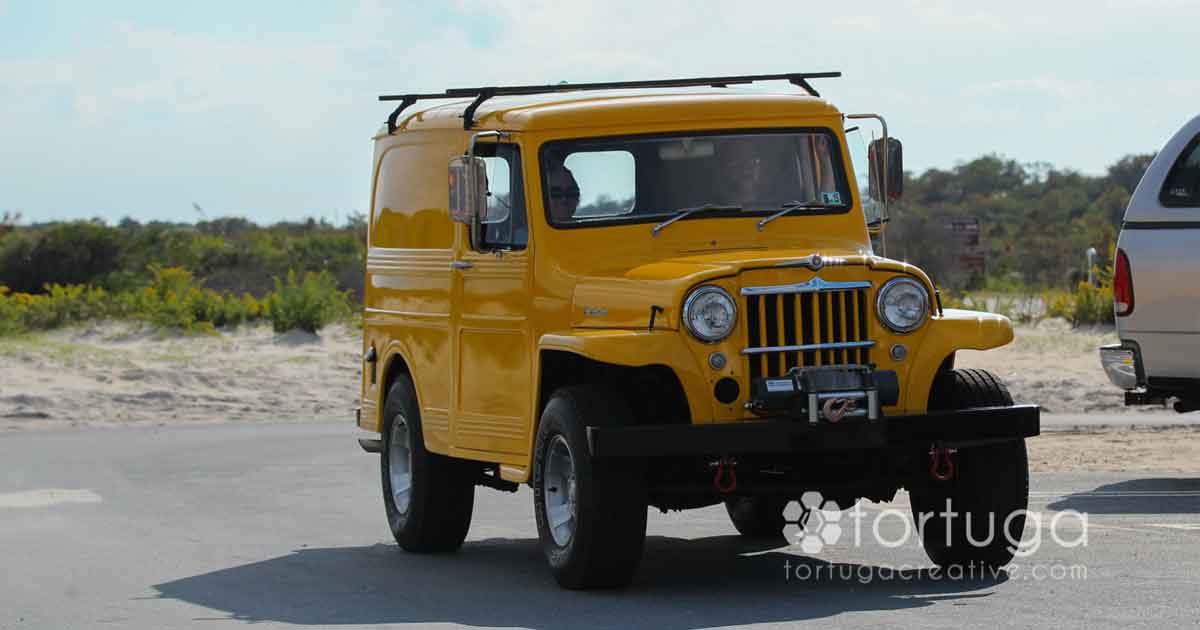 yellow jeep on beach dune